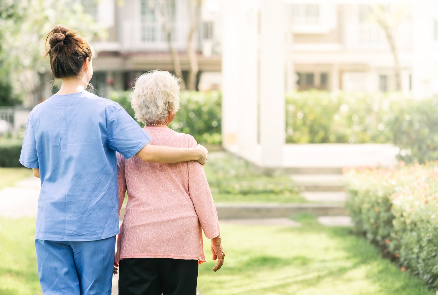 Caregiver with her arm around a smiling senior at home